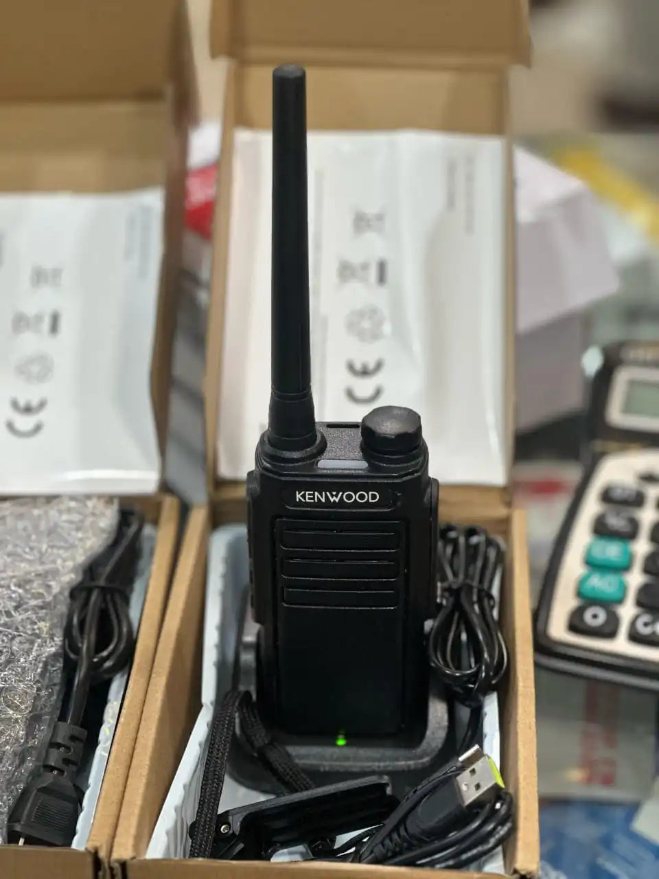 Pair of Kenwood TK-C1 walkie talkies with belt clips and accessories on display